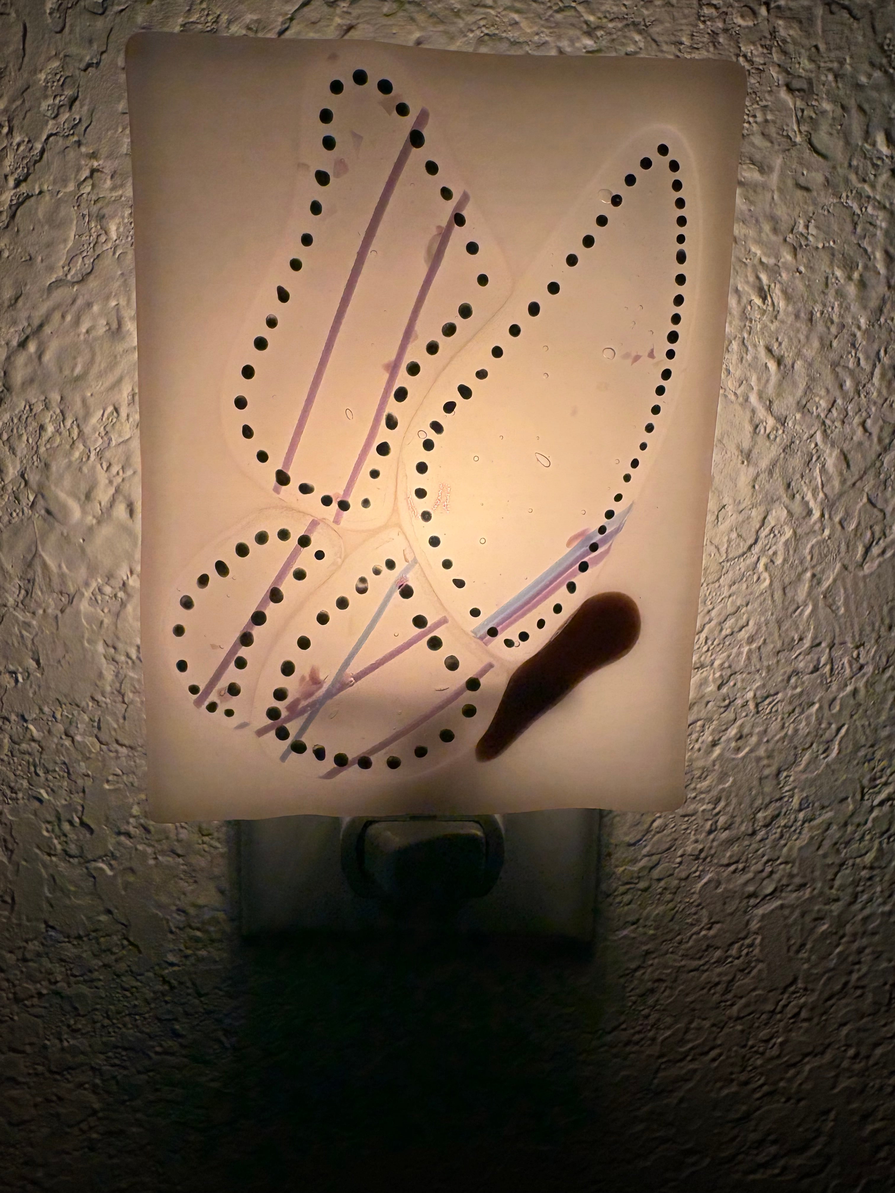 Fused glass dragonfly nightlight - unlit, showing clear background with black dot wing detail and lavender stringers