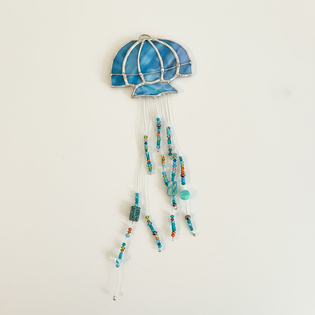 Close-up of a blue stained glass jellyfish with colorful beaded tentacles